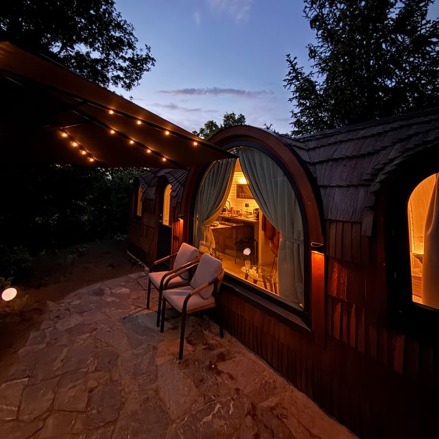 Beleuchtetes Chalet mit Terrasse und Lichterketten in der blauen Stunde