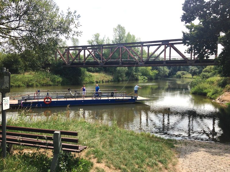 Flussfähre mit Fahrrädern unter einer Brücke bei Bamberg