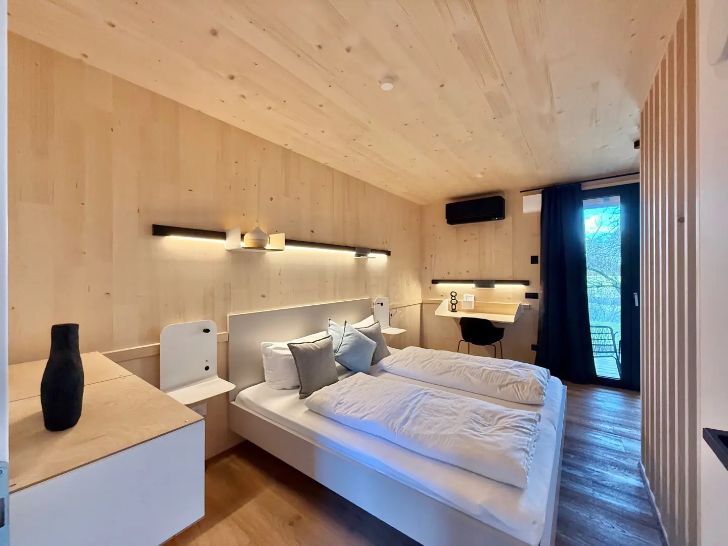 Schlafzimmer im Loft mit Holzwänden, Arbeitsplatz und Balkontür