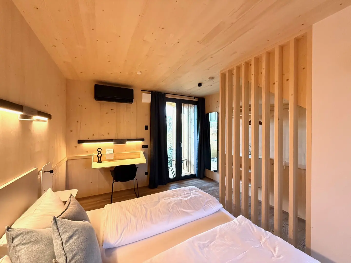 Schlafbereich im Loft mit Schreibtisch und Lamellenwand aus Holz