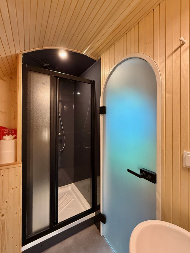 Badezimmer im Chalet mit Dusche und rundbogiger Tür